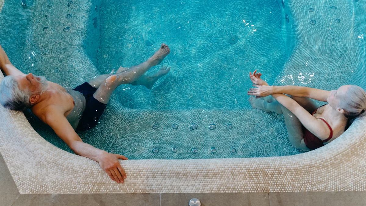 Elderly couple enjoying leisure time in a swimming pool. Overhead view.